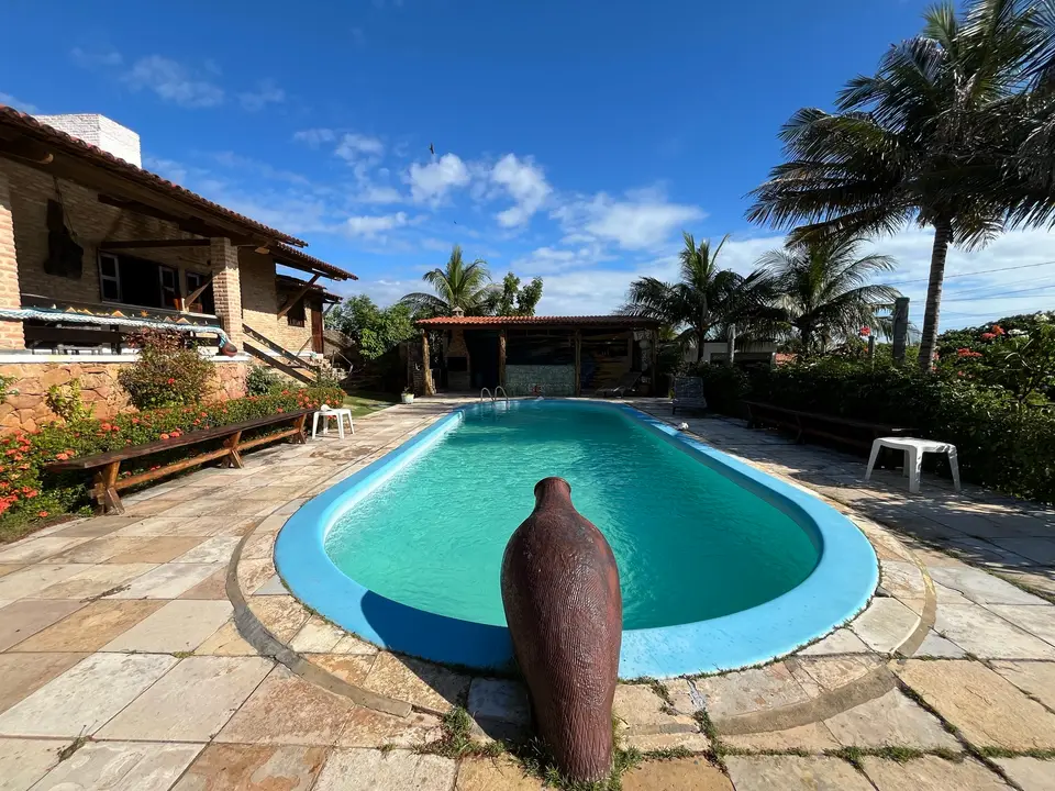 Piscina com bica d'água e jardim tropical